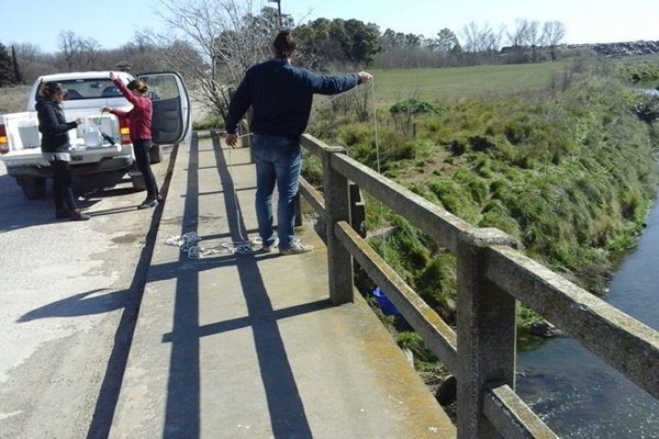 Foto de técnicos tomando muestras en el arroyo